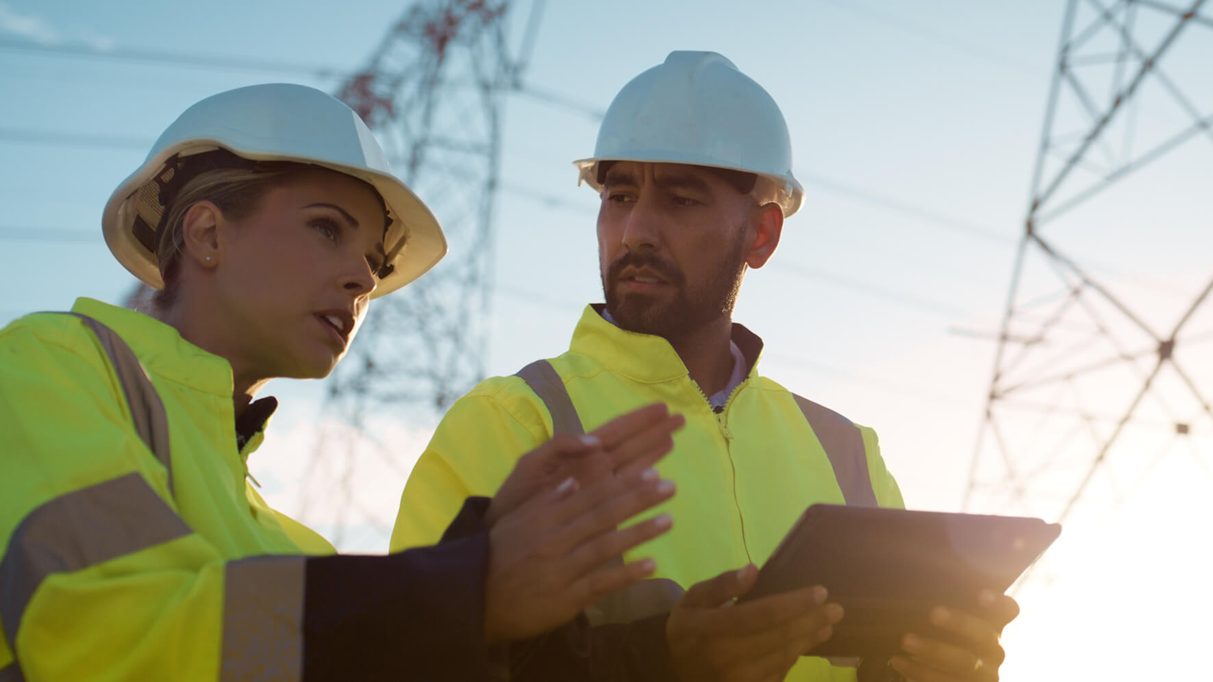 Utilities workers standing near pylons